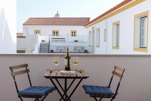 Casa dos Lacerdas في موراو: طاولة مع كرسيين وزجاجة من النبيذ