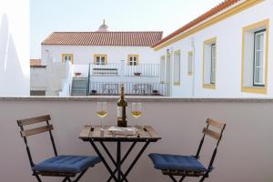 a table with two chairs and a bottle of wine at Casa dos Lacerdas in Mourão