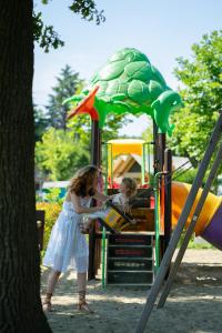 Una niña y un niño jugando en un patio de recreo. en Camping Lido Verbano, en Castelletto sopra Ticino