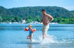 a man and a little girl playing in the water at Camping Lido Verbano in Castelletto sopra Ticino