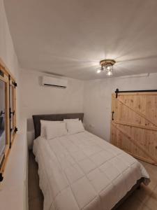 a bedroom with a large bed with a wooden door at Aprosmeno Jacuzzi House 3 With Private Pool in Agros