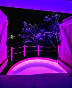 a purple lighted walkway with a tree in the background at Aprosmeno Jacuzzi House 3 With Private Pool in Agros