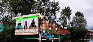a boat on the water with a green roof at H.B.victoria Garden in Srinagar