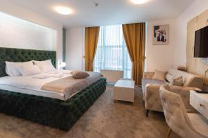 um quarto com uma grande cama verde e um sofá em Hotel IDEAL Deluxe em Novi Pazar