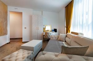 uma sala de estar com um sofá e uma mesa em Hotel IDEAL Deluxe em Novi Pazar