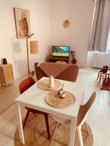 sala de estar con mesa blanca y sillas en Studio Renard, style bohème et atypique, Curistes, en Luxeuil-les-Bains
