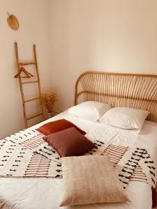 a bed with two pillows and a blanket on it at Studio Renard, style bohème et atypique, Curistes in Luxeuil-les-Bains