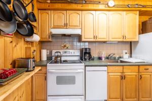 - une cuisine avec des appareils blancs et des armoires en bois dans l'établissement Mountainside Haven - walk to Hunter Mtn!, à Hunter