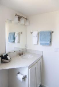 uma casa de banho com lavatório, espelho e toalhas em H - Cochito em Fort Bragg