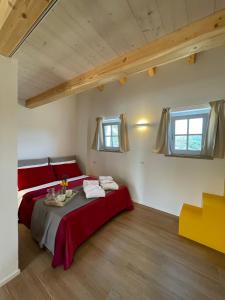 a bedroom with a large bed with red pillows at STAZZU LU CHISSONI in Luogosanto