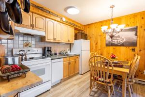 cocina con armarios de madera y mesa de madera con comedor en Mountainside Haven - walk to Hunter Mtn!, en Hunter