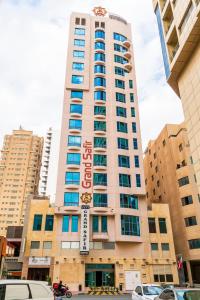 un edificio alto con un cartel encima en Grand Safir Hotel en Manama