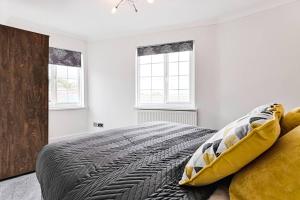 a bedroom with a large bed and two windows at 3-bed in Mumbles with free parking & sea views in The Mumbles