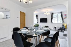 uma sala de jantar com uma mesa e cadeiras pretas em 3-bed in Mumbles with free parking & sea views em The Mumbles