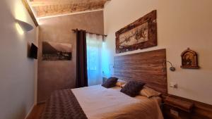 Schlafzimmer mit einem Bett mit einem Kopfteil aus Holz in der Unterkunft Masetto in Madonna di Campiglio