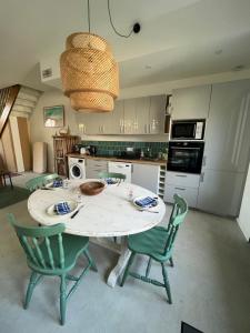 a kitchen with a table and chairs and aendant light at La Maison du Gardien in La Rochelle