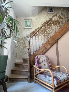 une chaise dans une pièce avec escalier dans l'établissement La Maison du Gardien, à La Rochelle