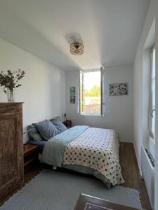 a bedroom with a bed and a window at La Maison du Gardien in La Rochelle