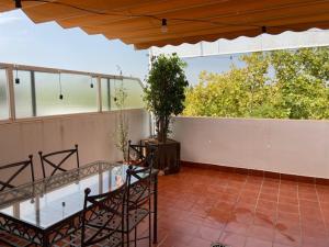 a balcony with a glass table and a potted plant at Torneo Atico Premium Apartment in Seville