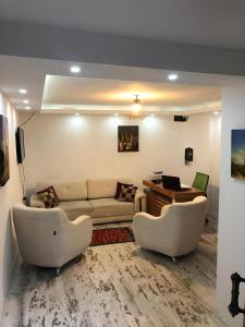 BLUE ROYAL HOTEL في إسطنبول: غرفة معيشة مع أريكة وكرسيين