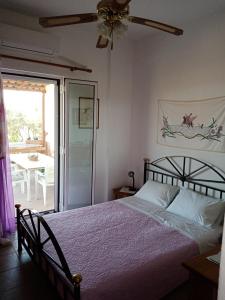 een slaapkamer met een bed en een plafondventilator bij Triopetra hill view in Triopetra