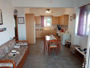 een woonkamer en een keuken met een tafel en een bank bij Triopetra hill view in Triopetra