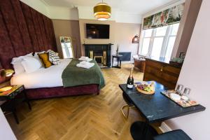 ein Hotelzimmer mit einem Bett und einem Tisch mit einem Tablett mit Speisen in der Unterkunft Dragon Villas by Maison Parfaite - Luxury Studios & Apartments - Harrogate in Harrogate