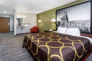 a hotel room with a large bed with a large picture on the wall at Super 8 by Wyndham Amarillo Central TX in Amarillo
