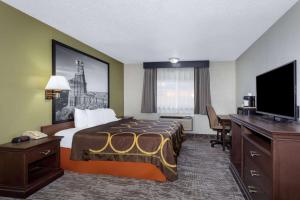a hotel room with a bed and a flat screen tv at Super 8 by Wyndham Amarillo Central TX in Amarillo