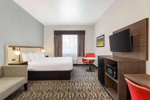 a hotel room with a bed and a flat screen tv at Ramada by Wyndham Marina in Marina