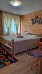 a bedroom with a large bed in a wooden room at Cabana Dochita in Ceahlău