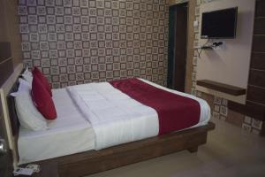 um quarto com uma cama com almofadas vermelhas e brancas em The Sky Comfort - Hotel The Heaven, Dwarka em Dwarka