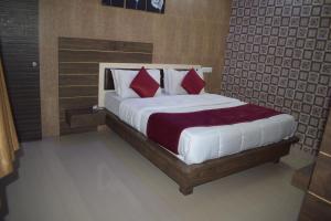 um quarto com uma cama grande e almofadas vermelhas em The Sky Comfort - Hotel The Heaven, Dwarka em Dwarka