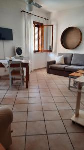 ein Wohnzimmer mit einem Sofa und einem Tisch in der Unterkunft Le Ciaramire in Favignana
