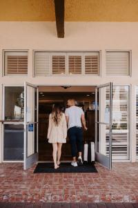 Ein Mann und eine Frau gehen in ein Gebäude in der Unterkunft Best Western Sonoma Winegrower's Inn in Rohnert Park