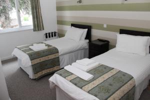 a hotel room with two beds with towels on them at Ravenswood Social Club in Banchory