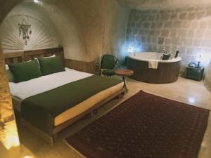 ネヴシェヒルにあるVigneron Cave Hotelのベッドルーム(ベッド1台、バスタブ付)