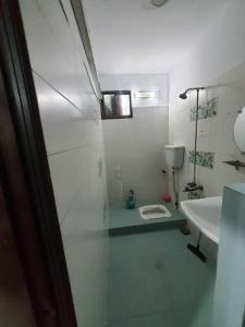 Baño blanco con lavabo y aseo en Patel Residency Apartment en Karachi