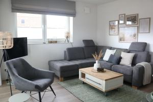 ein Wohnzimmer mit einem Sofa und einem Tisch in der Unterkunft Fewo  Hammersee  Haus Juist Whg 2 in Hooksiel