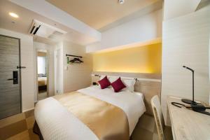 a bedroom with a bed with red pillows and a desk at Best Western Hotel Fino Tokyo Akasaka in Tokyo