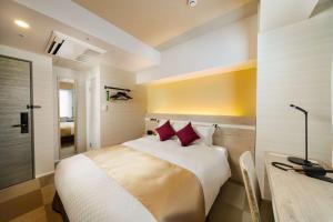1 dormitorio con cama con almohadas rojas y escritorio en Best Western Hotel Fino Tokyo Akasaka, en Tokio