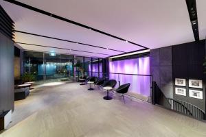 a lobby with a row of chairs and purple lights at Best Western Plus Hotel Fino Osaka Kitahama in Osaka