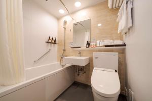 a bathroom with a toilet and a sink and a tub at Best Western Plus Fukuoka Tenjin-minami in Fukuoka +88 photos