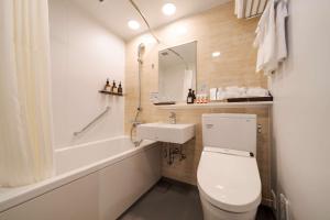 a bathroom with a toilet and a sink and a tub at Best Western Plus Fukuoka Tenjin-minami in Fukuoka