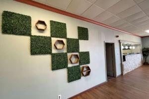 una pared con plantas verdes en una pared en una oficina en Days Inn & Suites by Wyndham Springfield OH, en Springfield