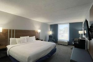 a hotel room with a large bed and a window at Days Inn & Suites by Wyndham Springfield OH in Springfield