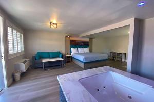a bathroom with a tub and a bedroom with a bed at Super 8 by Wyndham Oceanside Downtown in Oceanside