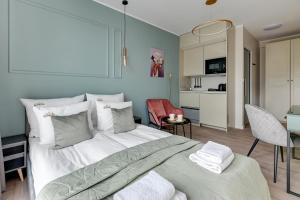 a bedroom with a large bed and a kitchen at Downtown Apartments City Center Aura 40 in Gdańsk