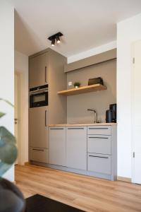 a kitchen with white cabinets and a sink at Suites Lohne in Lohne