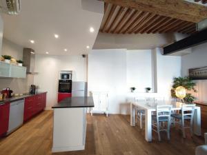 a kitchen with red and white cabinets and a table at Esquiros in La Ciotat